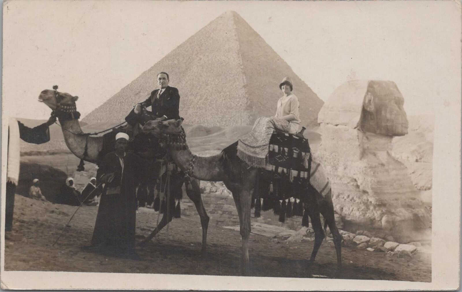 RPPC postcard Sahara Desert Couple Riding Camels in front of Pyramids 1900s